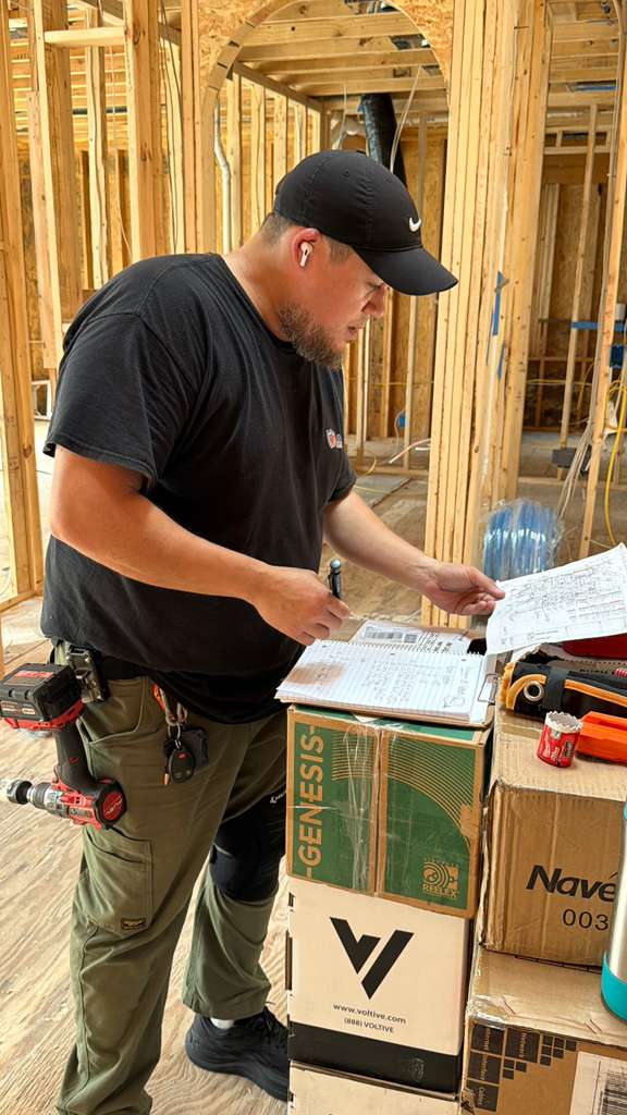Armor Security Solutions technician reviewing low-voltage drawings during residential framing stage